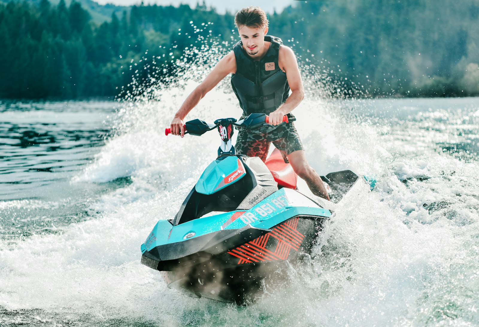A rider carving across a sunny lake on a personal watercraft during riding season